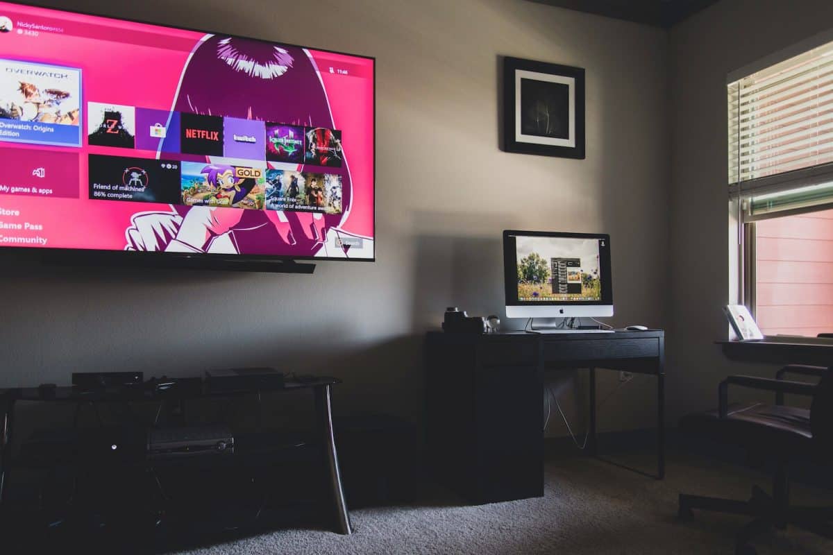 black flat screen tv turned on near black wooden table